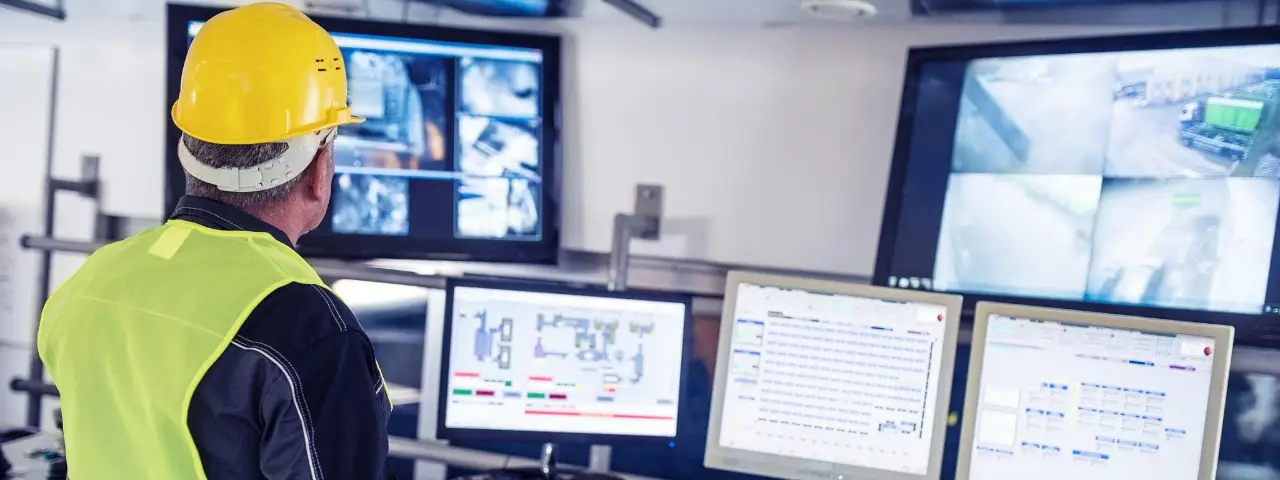 A safety worker monitoring CCTV cameras in a controlled room