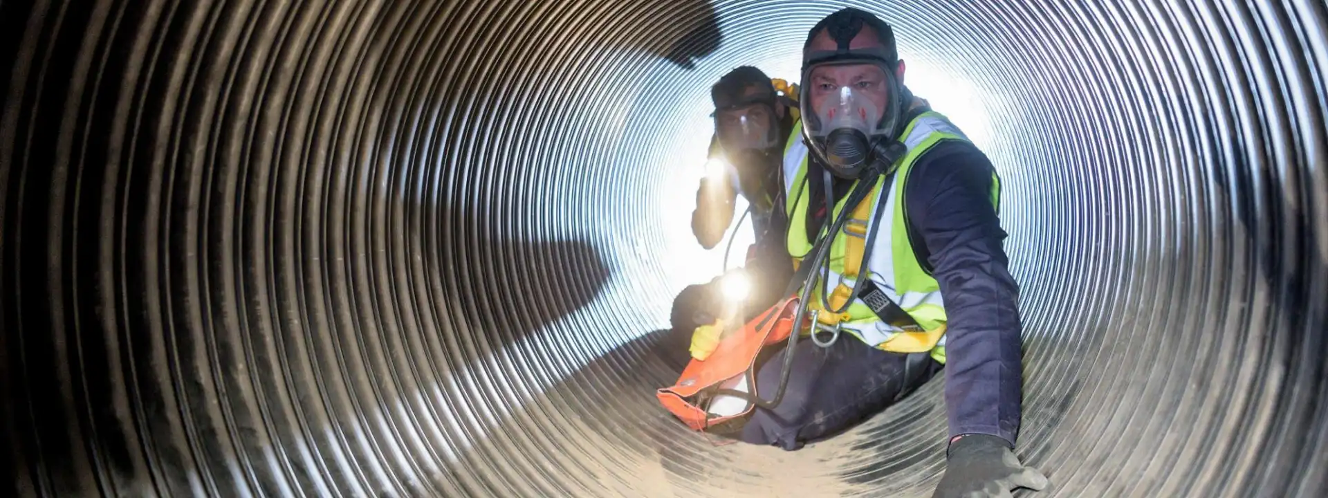 A safety worker conducting an inspection for hazards in a confined space