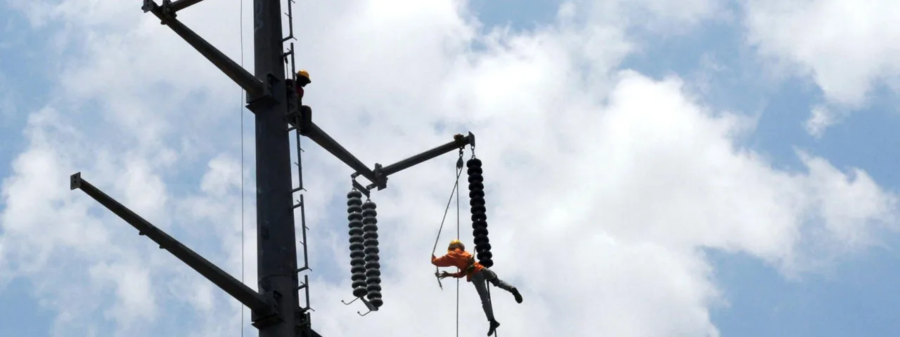 A person performing energized electrical work at a height
